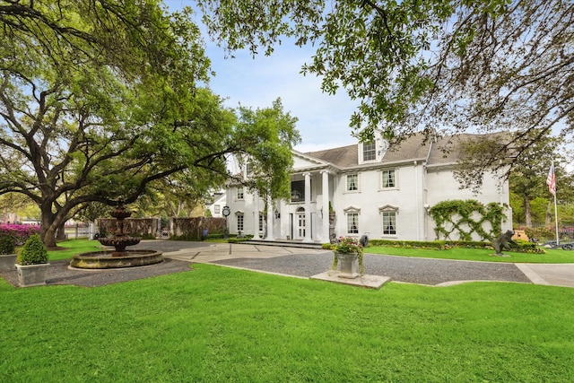 rear view of property featuring a lawn