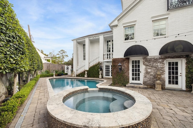 exterior space featuring an in ground hot tub and a patio area