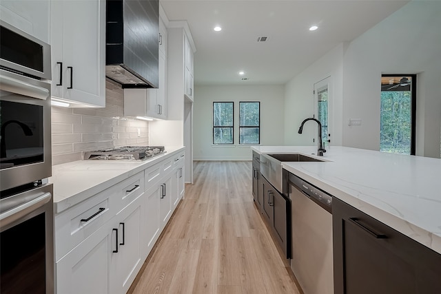 kitchen featuring white cabinets, appliances with stainless steel finishes, plenty of natural light, and sink