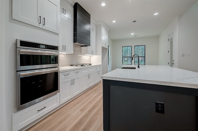 kitchen featuring appliances with stainless steel finishes, white cabinetry, and custom exhaust hood