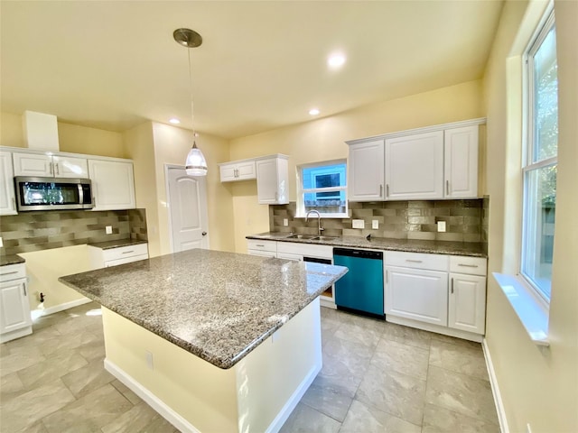 kitchen with sink, white cabinets, stainless steel appliances, and a kitchen island