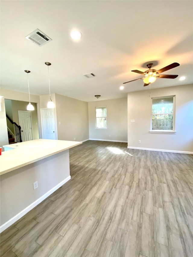 unfurnished living room featuring ceiling fan and light hardwood / wood-style floors