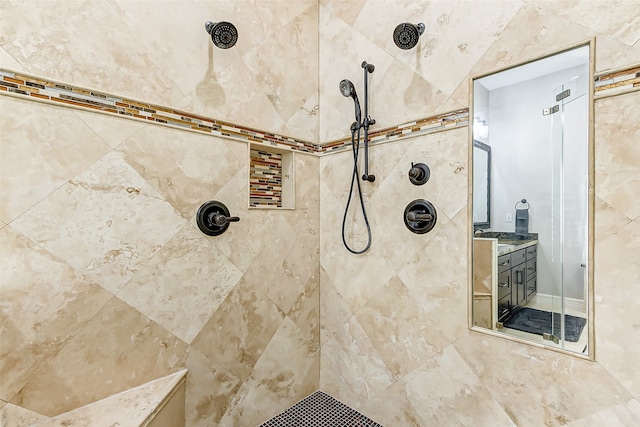 bathroom with vanity and a tile shower