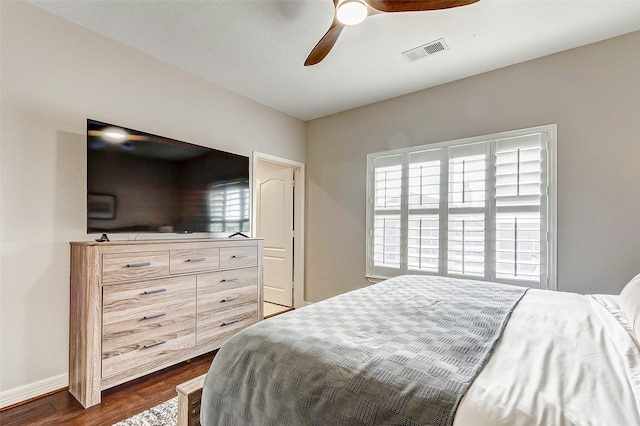 bedroom featuring dark wood-type flooring, multiple windows, and ceiling fan