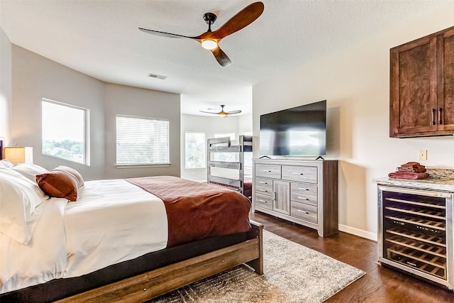 bedroom with multiple windows, wine cooler, dark wood-type flooring, and ceiling fan