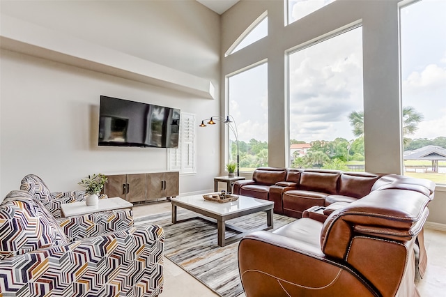 tiled living room featuring a towering ceiling