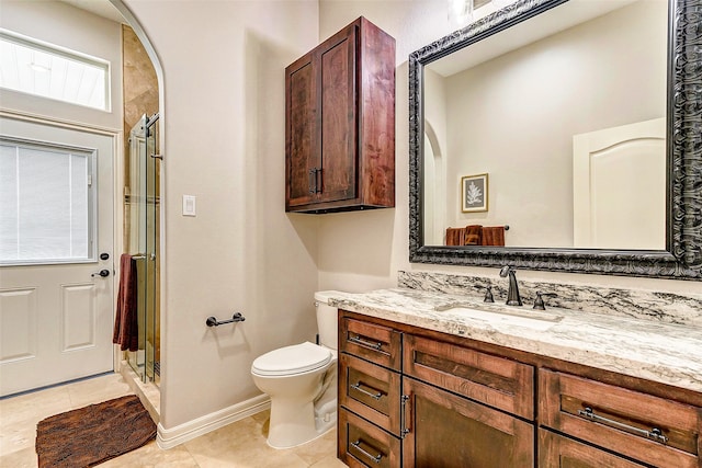 bathroom featuring a shower with door, vanity, toilet, and tile patterned flooring