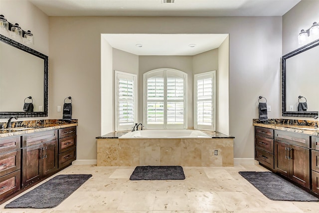 bathroom with vanity and tiled bath