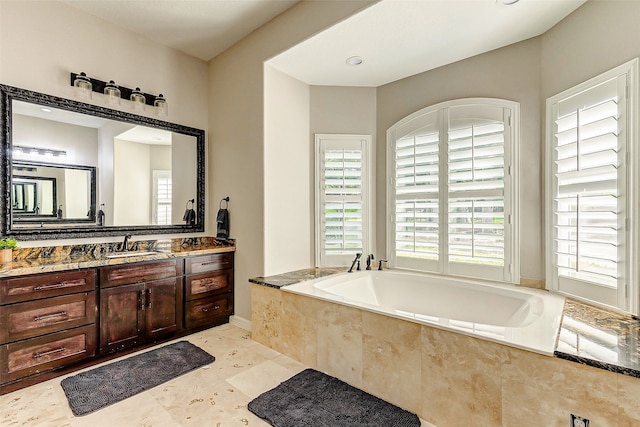 bathroom with vanity, tile patterned flooring, and tiled tub