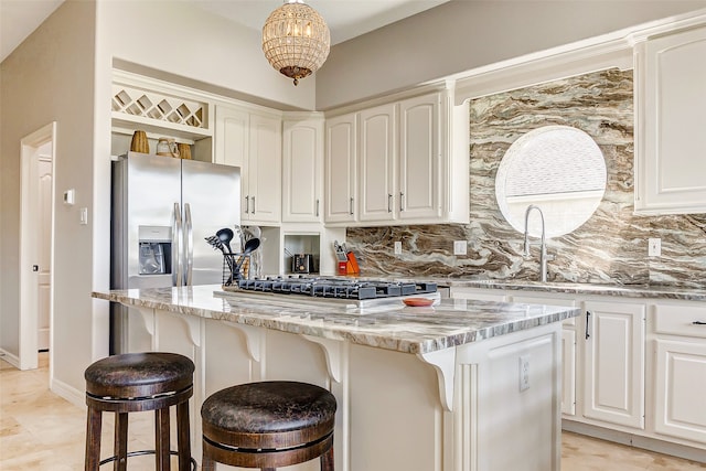 kitchen with light stone counters, tasteful backsplash, a center island, and stainless steel appliances