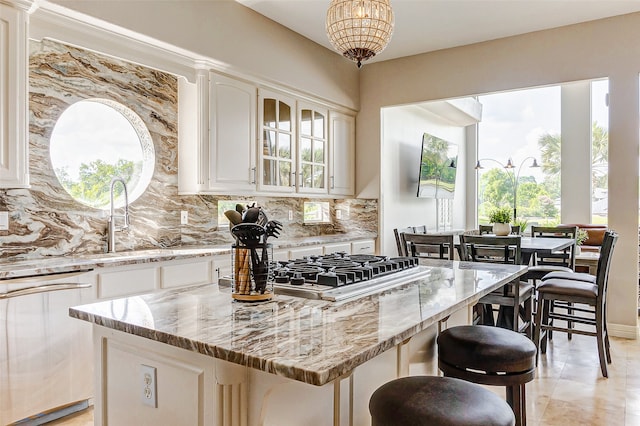 kitchen with dishwasher, light stone counters, and a kitchen island