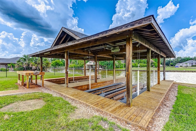 dock area with a lawn and a water view