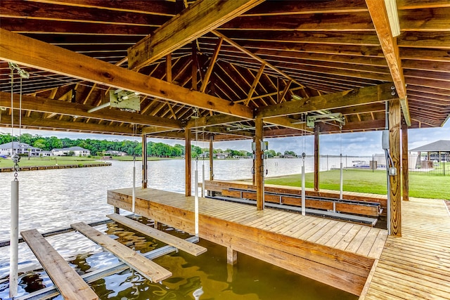 view of dock featuring a water view and a yard