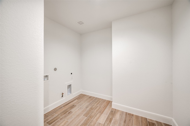 laundry area featuring hookup for a gas dryer, light hardwood / wood-style floors, washer hookup, and hookup for an electric dryer