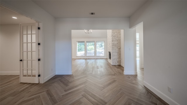 corridor with parquet floors and an inviting chandelier