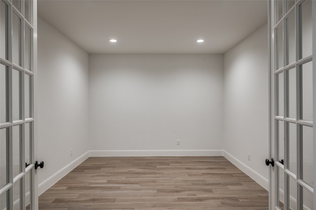 empty room with french doors and light hardwood / wood-style flooring