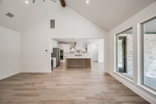 unfurnished living room featuring beam ceiling, a chandelier, high vaulted ceiling, and light hardwood / wood-style floors