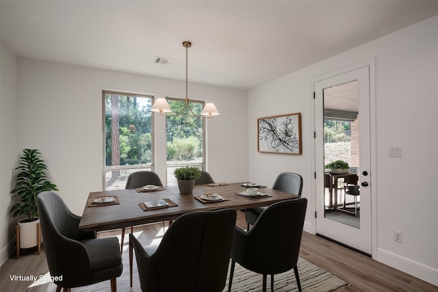 dining room featuring plenty of natural light, a notable chandelier, and hardwood / wood-style flooring