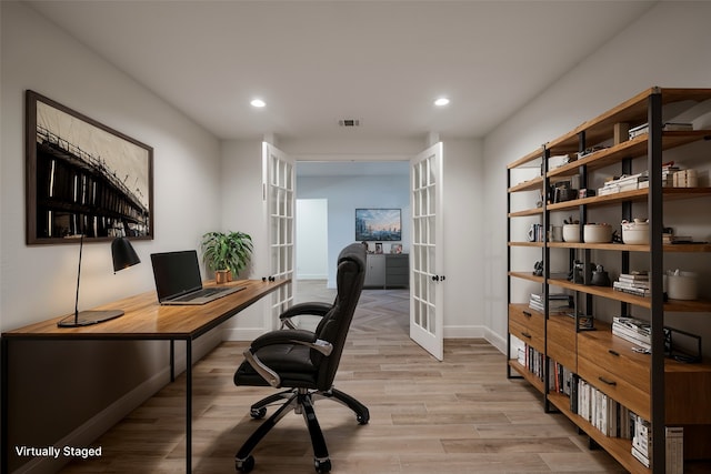 home office with light wood-type flooring and french doors