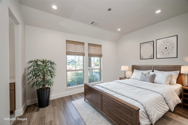 bedroom with vaulted ceiling and hardwood / wood-style flooring