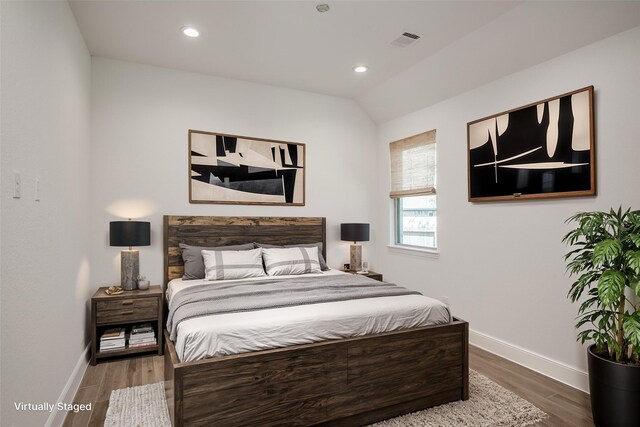 bedroom featuring hardwood / wood-style floors and vaulted ceiling