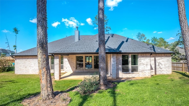 rear view of house featuring a yard and a patio