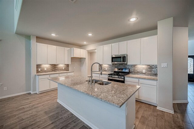 3423 Hackberry Tree Ln, Katy, TX 77449 - kitchen featuring appliances with stainless steel finishes, a sink, light wood-type flooring, decorative backsplash, and white cabinets
