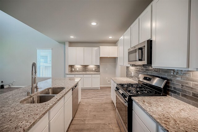 3423 Hackberry Tree Ln, Katy, TX 77449 - kitchen with appliances with stainless steel finishes, light wood-style flooring, light stone countertops, a sink, and recessed lighting