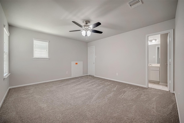 3423 Hackberry Tree Ln, Katy, TX 77449 - unfurnished bedroom with light colored carpet, baseboards, ensuite bathroom, and a ceiling fan