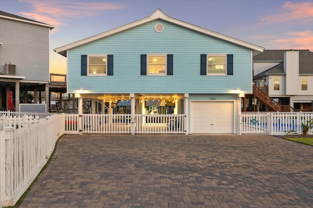 view of front of house with a garage and central air condition unit