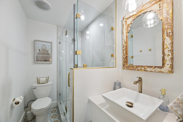 bathroom with an enclosed shower, vanity, and toilet