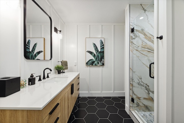 bathroom featuring tile patterned flooring, a shower with door, and vanity