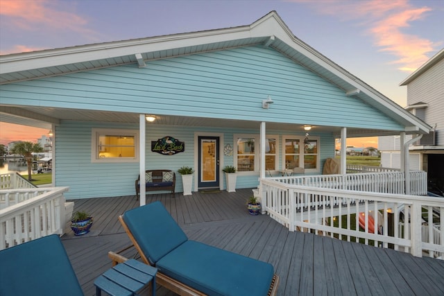 back house at dusk with a deck