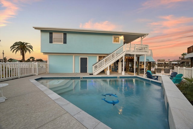 pool at dusk with a patio