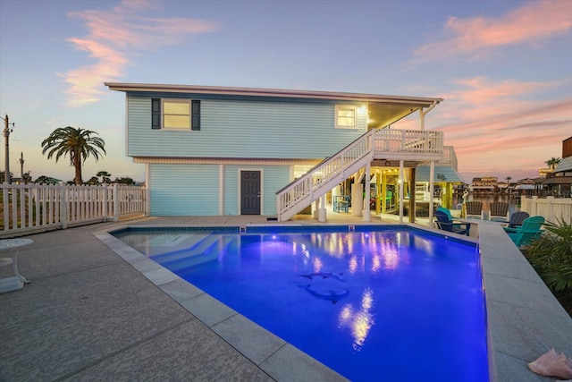 pool at dusk featuring a patio area