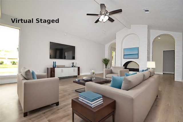 living room featuring light hardwood / wood-style floors, lofted ceiling with beams, and ceiling fan