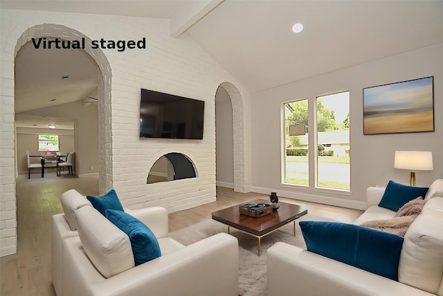 living room with lofted ceiling with beams, light wood-type flooring, and a wealth of natural light