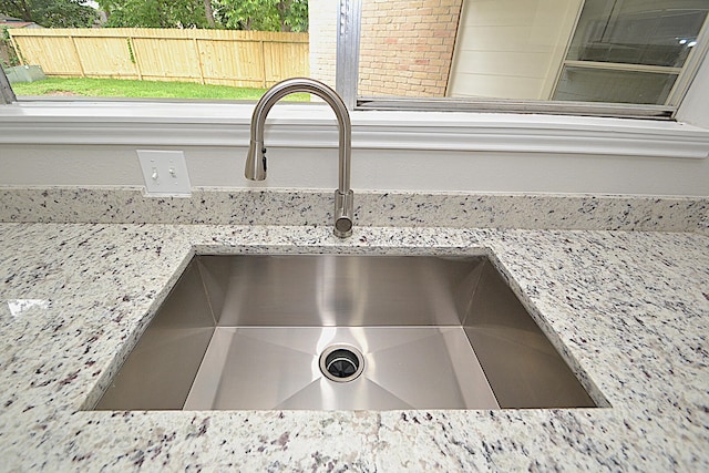 interior details featuring light stone counters and sink