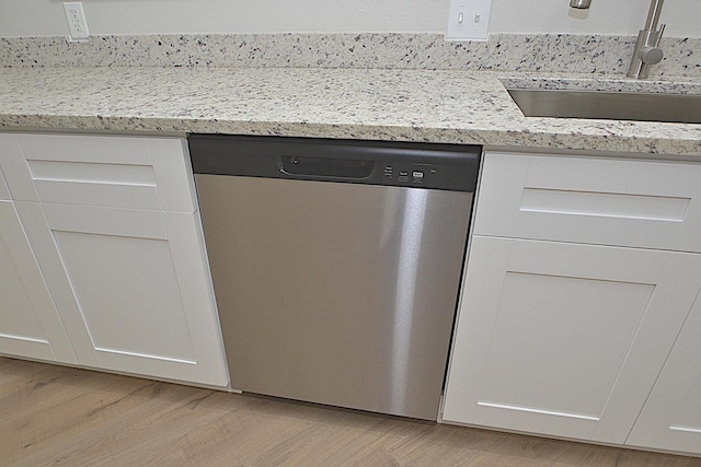 details featuring light hardwood / wood-style floors, stainless steel dishwasher, white cabinetry, and sink