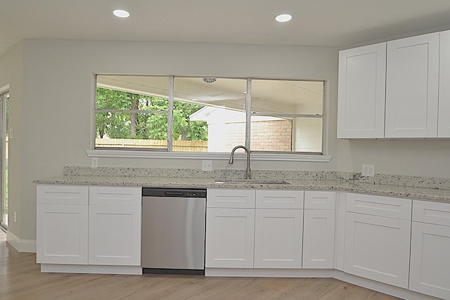 kitchen featuring dishwasher, sink, and white cabinetry