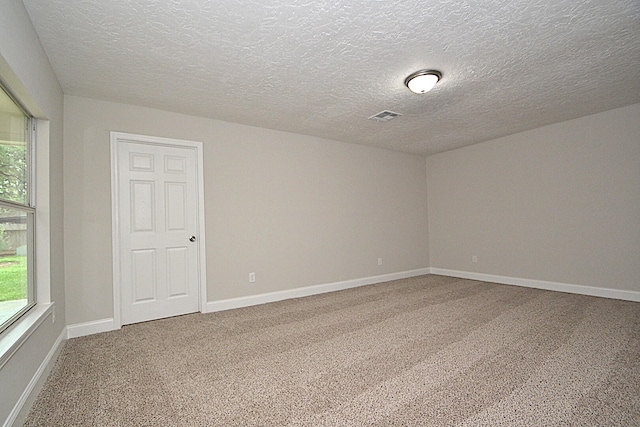 carpeted spare room with a textured ceiling