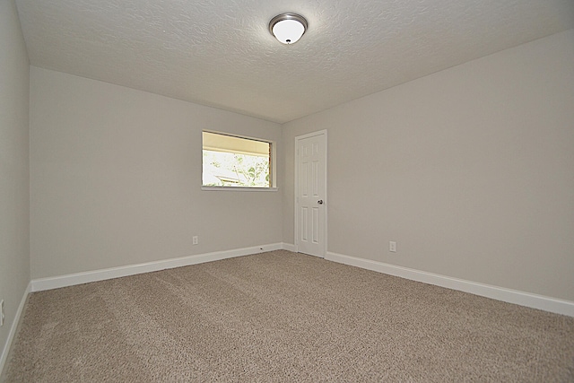 carpeted spare room featuring a textured ceiling