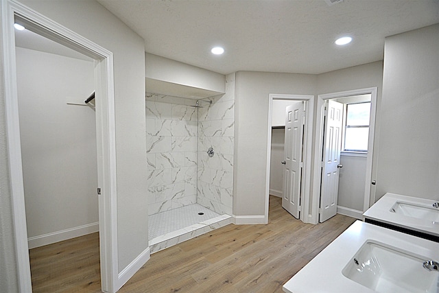 bathroom with vanity, hardwood / wood-style flooring, and a tile shower