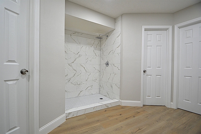 bathroom featuring a tile shower and hardwood / wood-style floors