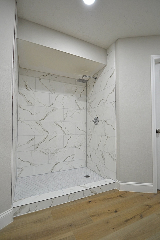 bathroom featuring a tile shower and hardwood / wood-style flooring