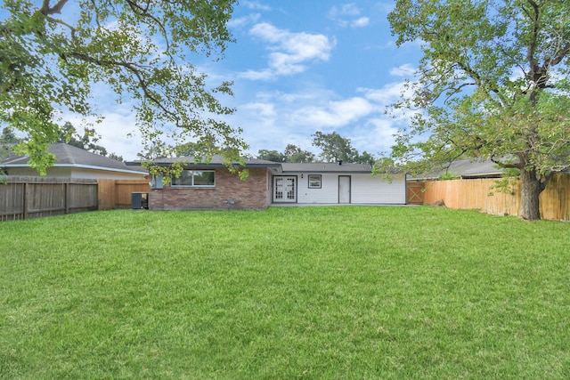 rear view of property featuring a lawn