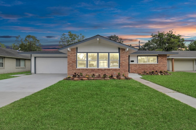 single story home featuring a lawn and a garage