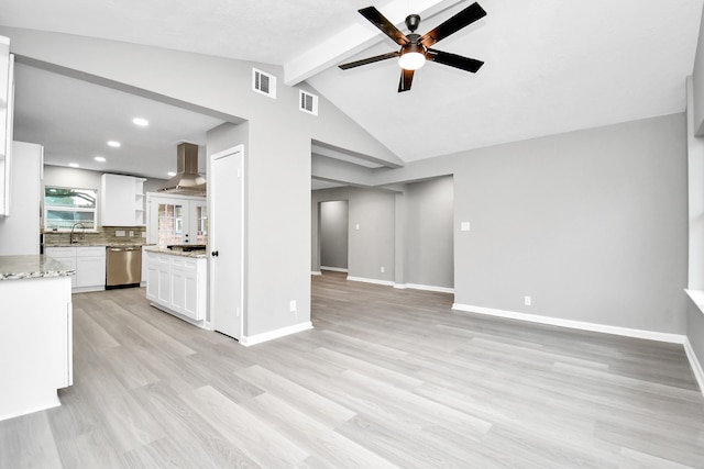 unfurnished living room with light wood-type flooring, vaulted ceiling with beams, sink, and ceiling fan