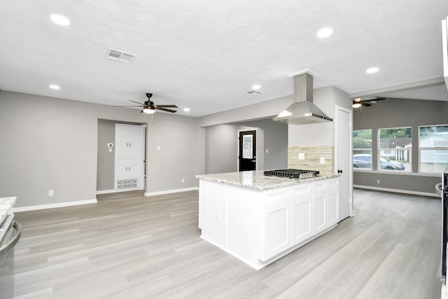 kitchen featuring decorative backsplash, white cabinets, light stone countertops, ventilation hood, and light hardwood / wood-style flooring