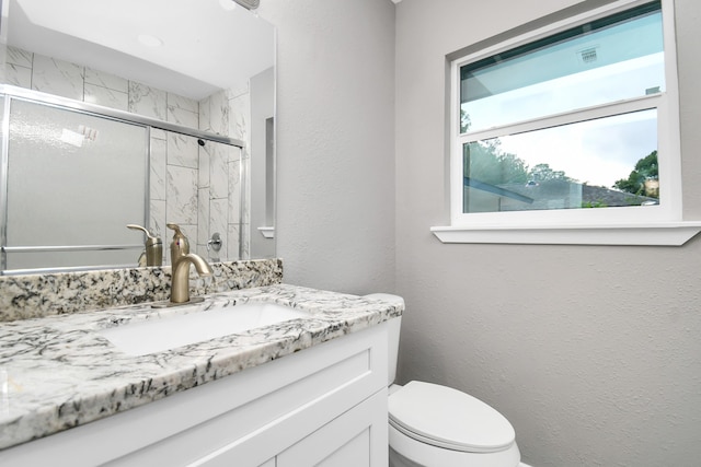 bathroom featuring walk in shower, vanity, and toilet